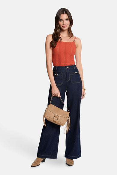 T-shirt sans manches orange de Morgan De Toi, avec un motif ondulé et porté avec des jeans larges et une sacoche en cuir.