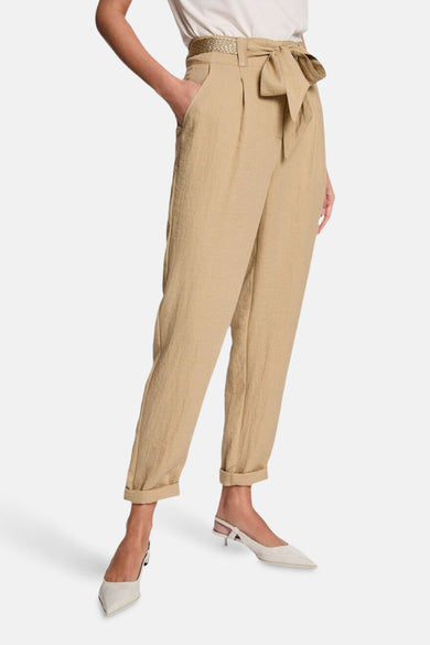 Pantalon beige de Morgan De Toi, avec une ceinture tressée, des revers de jambe et des talons blancs.