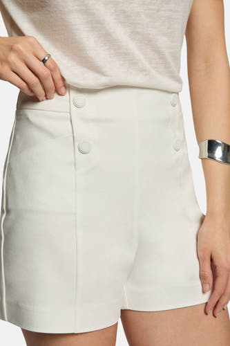 Witte korte broek van Morgan De Toi met knopen en zijstreep, close-up van model met zilveren armband