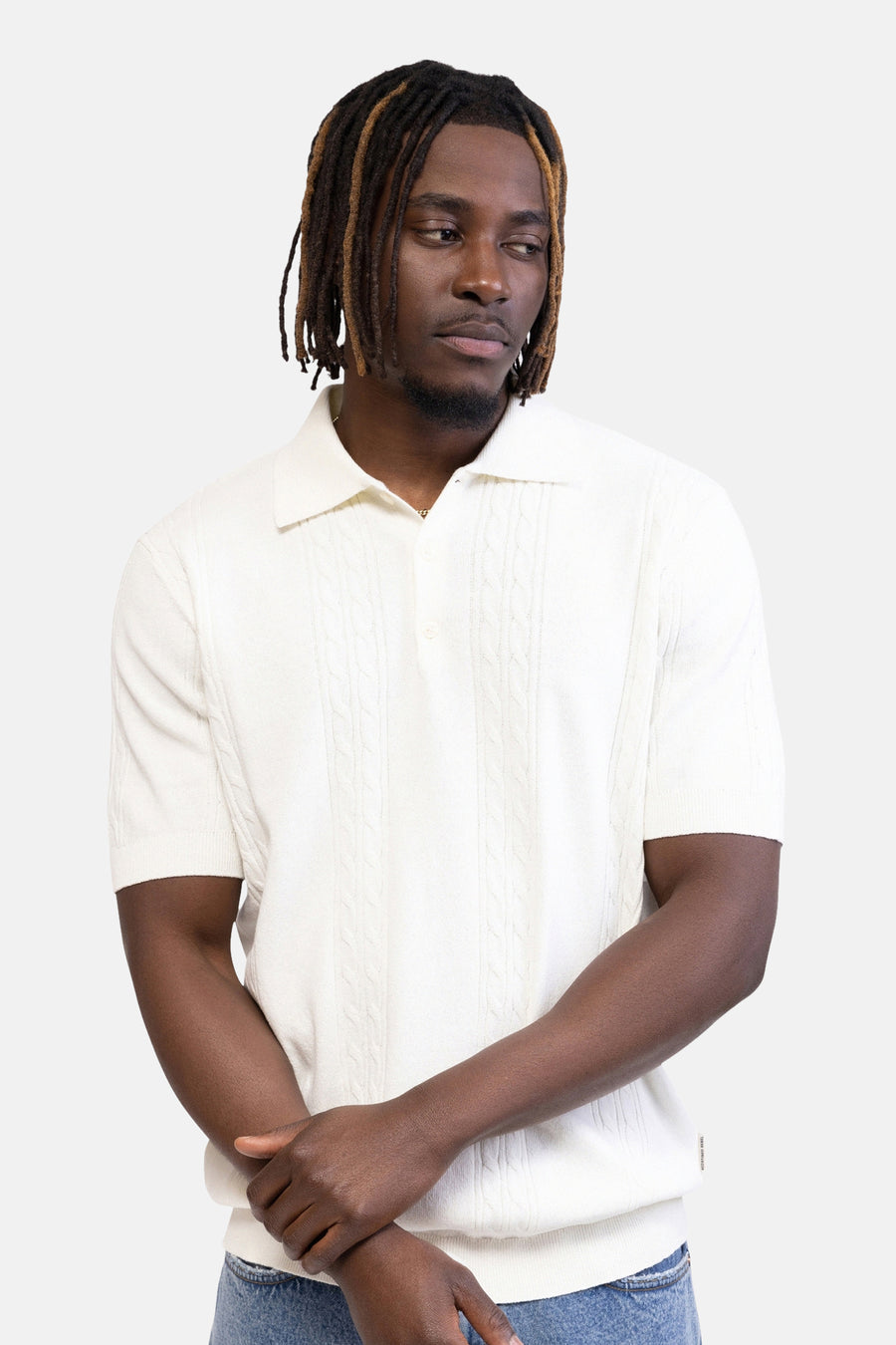 Polo écru de REDEFINED REBEL, tricoté avec un motif torsadé, manches courtes, dos sur une personne portant un jean.