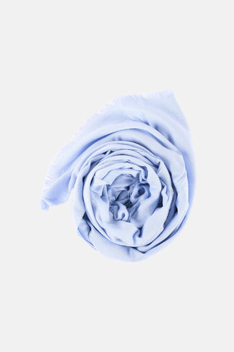 Blauwe zomersjaal van Morgan De Toi, opgerold weergegeven, met een fijne geweven textuur en franjes.
