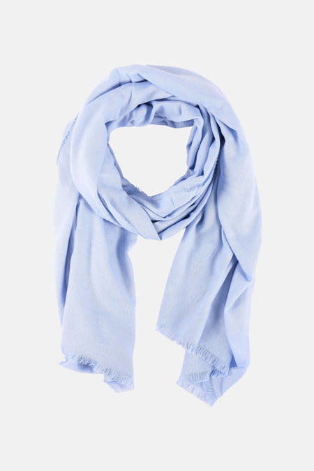 Blauwe zomersjaal van Morgan De Toi, met een zachte textuur en gerafelde randen, losjes gedrapeerd.
