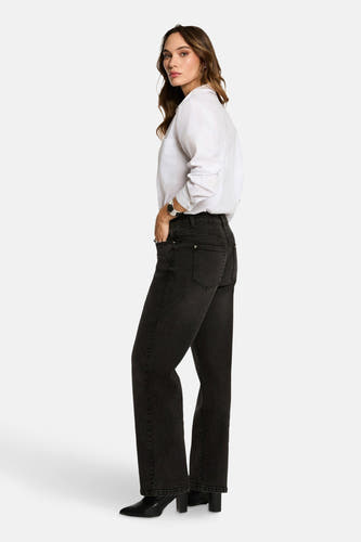 Wit, langarmig hemd van Morgan De Toi, met een losse pasvorm en gedragen met zwarte jeans en hakken.
