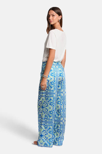 T-shirt blanc à manches courtes de Morgan De Toi, porté avec un pantalon bleu à imprimé paisley.
