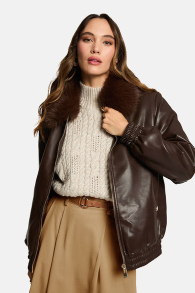 Bruine korte jas van Morgan De Toi met een bontkraag, gedragen met een beige trui en broek.
