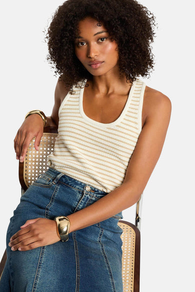 Ecru mouwloze top van Morgan De Toi, met gouden strepen en een denim rok met gouden armbanden.
