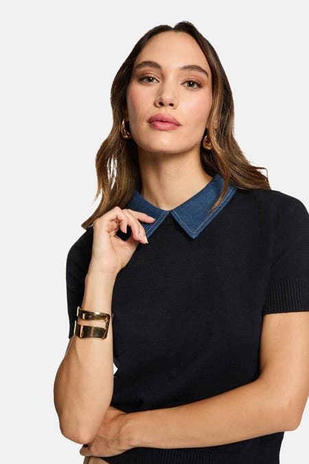 Blauwe trui met ronde hals van Morgan De Toi, met denim kraag en gouden armband.

