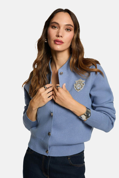 Blauw gilet van Morgan De Toi met sierknopen, gedragen met een donkere broek en zilverkleurige sieraden.