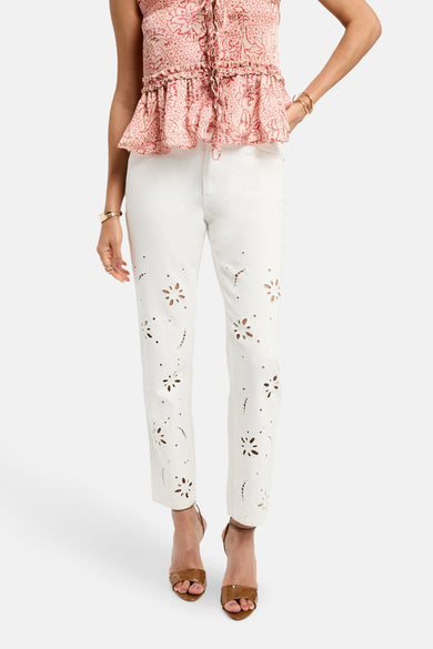 Witte broek van Morgan De Toi, met bloemendetails en gecombineerd met een roze top en bruine hakken.
