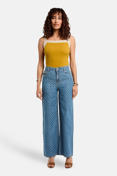 Blauwe denim broek van Morgan De Toi, met een opvallend ruitpatroon en een wijde pijp, gecombineerd met een okerkleurige top.
