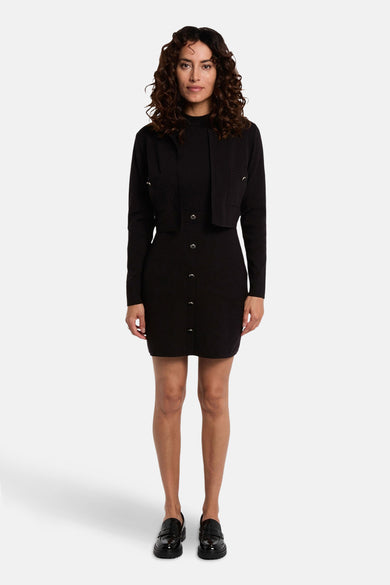 Robe noire à longues manches de Morgan De Toi, avec fermeture à boutons, associée à un court manteau noir et des chaussures noires.