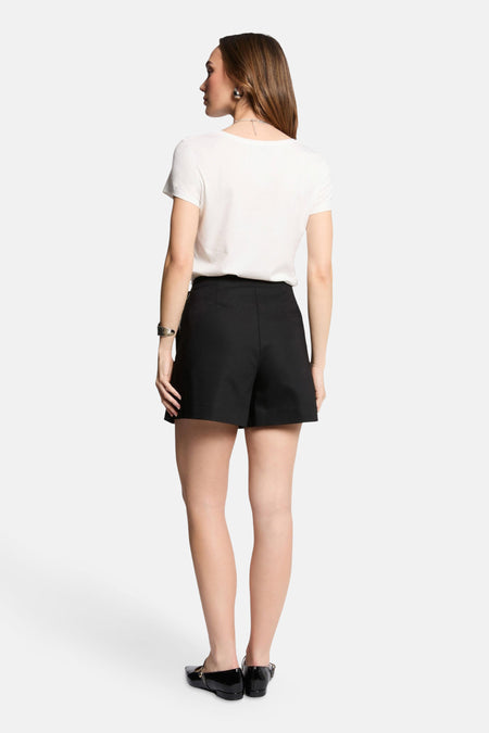 Jupe courte noire de Morgan De Toi, avec une chemise blanche et des chaussures noires.
