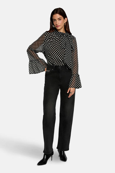 Blouse noire à manches longues de Morgan De Toi, avec un motif à points et des plis au col.
