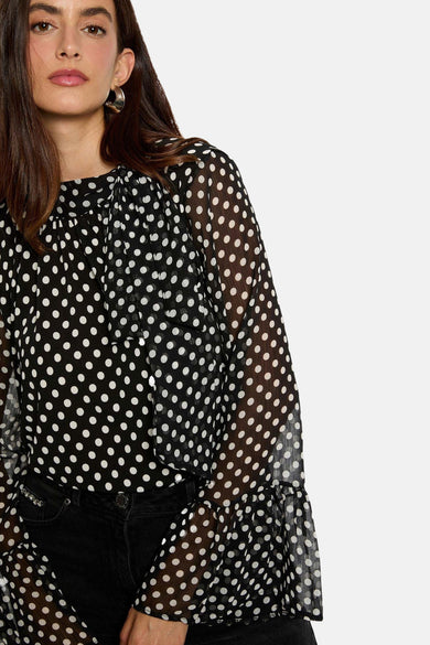 Blouse noire à manches longues de Morgan De Toi, avec des taches blanches et des plis sur les manches.