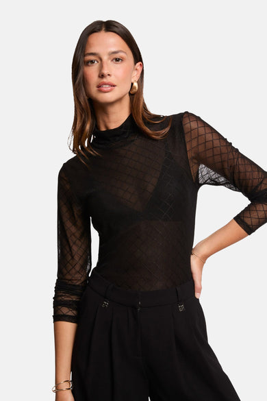 Zwarte blouse met lange mouwen van Morgan De Toi, met ruitjespatroon, gecombineerd met een zwarte pantalon.
