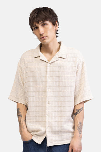 Chemise beige à manches courtes de REDEFINED REBEL, avec des rayures horizontales texturées, visible au dos d'un mannequin tatoué.