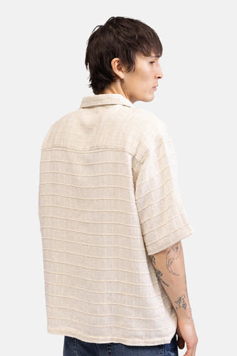 Beige overhemd met korte mouwen van REDEFINED REBEL, met gestructureerde horizontale strepen, zichtbaar op de achterkant van een model met tatoeages.