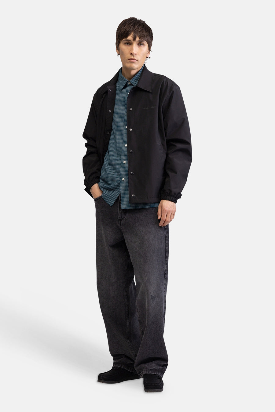 Chemise à manches courtes à carreaux verts de REDEFINED REBEL, avec de petits carreaux, portée sous une veste noire.