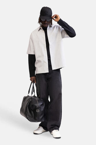 Chemise multicolore à manches courtes de REDEFINED REBEL, avec motif à petits carreaux, portée sur un t-shirt noir à manches longues.