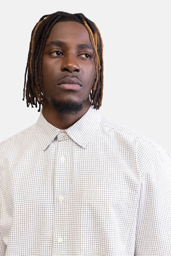 Chemise à carreaux légers de REDEFINED REBEL, à manches longues, portée par un homme avec des dreadlocks.
