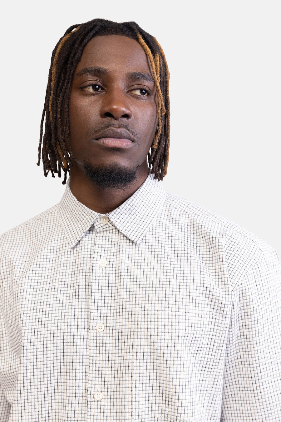 Chemise à carreaux légers de REDEFINED REBEL, à manches longues, portée par un homme avec des dreadlocks.