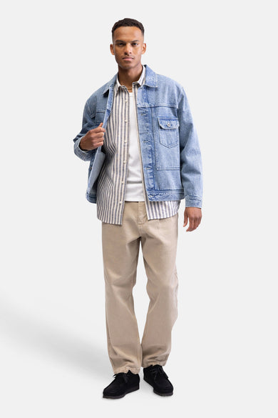 Chemise multicolore à manches longues de REDEFINED REBEL, à motif rayé, portée sous une veste en jean et avec un t-shirt blanc.