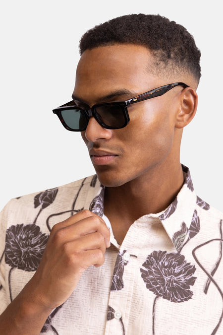 Multicolor korte mouwen overhemd van REDEFINED REBEL met bloemenprint, lichte stof, witte knopen, close-up van model met zonnebril