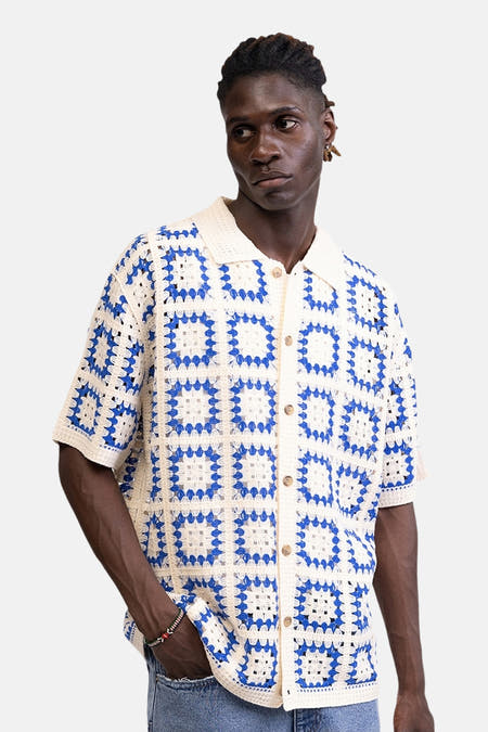 Multicolor gehaakte pull van REDEFINED REBEL met blauw-witte blokken en overhemdkraag op een mannelijk model.