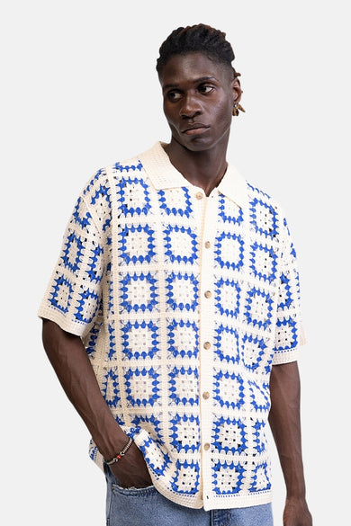 Multicolor gehaakte pull van REDEFINED REBEL met blauw-witte blokken en overhemdkraag op een mannelijk model.