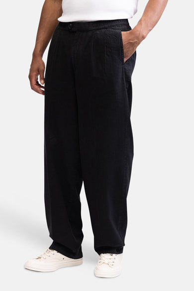 Zwarte losvallende broek van REDEFINED REBEL met geplooide voorkant en elastische tailleband.