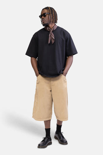 Short en velours côtelé beige de REDEFINED REBEL avec jambes larges et poches latérales, porté par un mannequin.