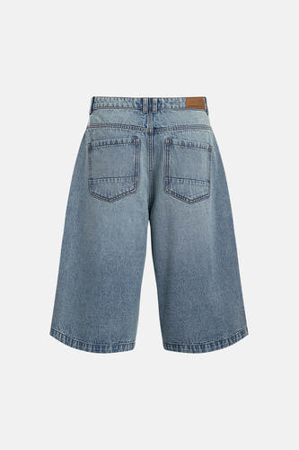 Short en jean bleu clair de REDEFINED REBEL, vue arrière avec jambes larges, deux poches arrière et patch de marque marron.