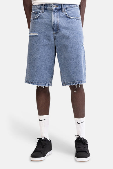 Mid blauwe denim short van REDEFINED REBEL met rafels en gaten, gedragen met witte sokken en zwarte sneakers.