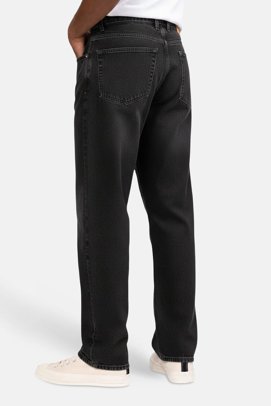 Donkergrijze wide jeans van REDEFINED REBEL, achterkant te zien, met lichte crèmekleurige schoenen.