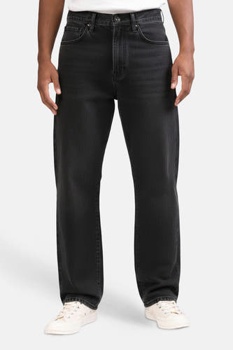 Donkergrijze denim wijde jeans van REDEFINED REBEL, met lichte slijtage en witte sneakers.