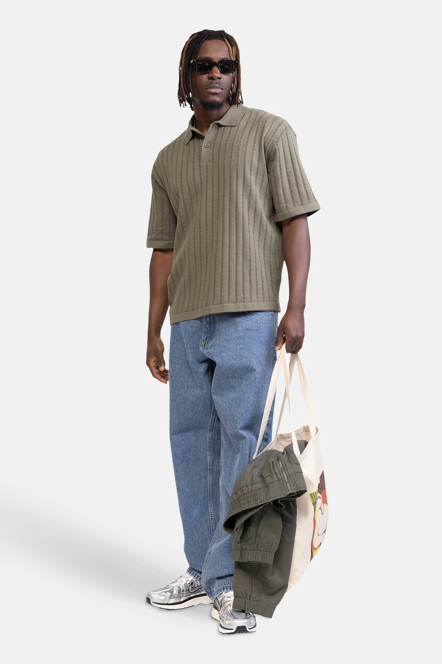 Jean en denim bleu clair de REDEFINED REBEL, combiné avec un polo vert côtelé et des baskets argentées.