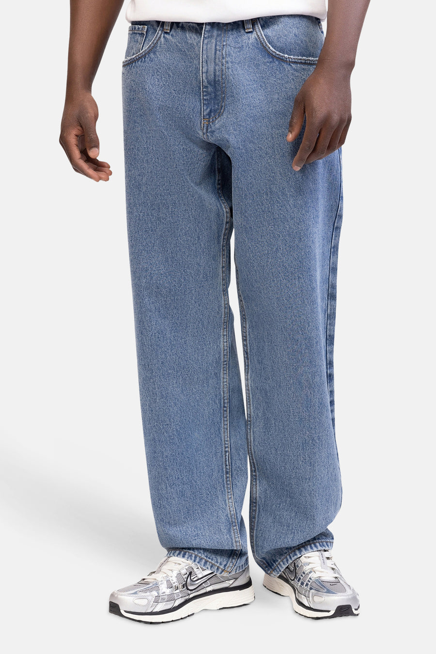 Jean 'wide' en denim bleu clair de REDEFINED REBEL, avec jambes larges et baskets grises.