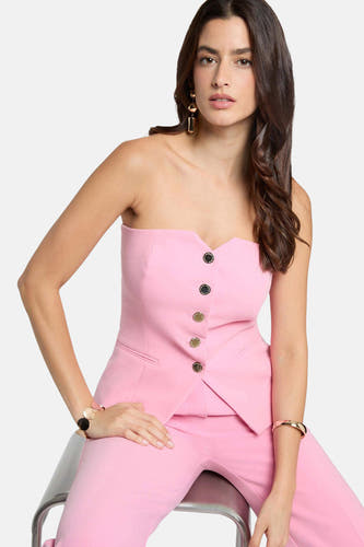 Gilet rose de Morgan De Toi avec fermeture à boutons, porté avec un pantalon assorti et des bijoux dorés.