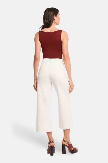 Haut (à fines bretelles) brique de Morgan De Toi, avec un décolleté droit, combiné avec un pantalon blanc et des talons marron.