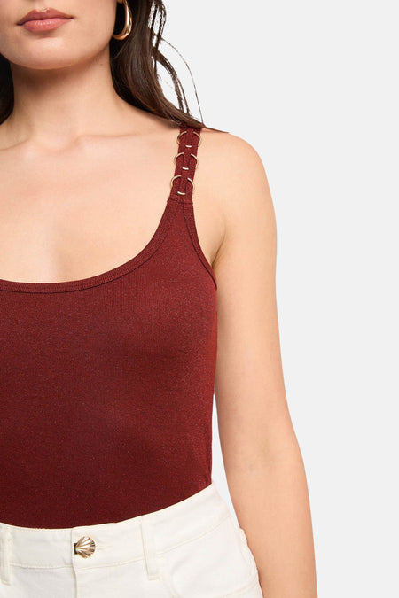 Haut bordeaux avec bretelles spaghetti de Morgan De Toi, avec détails d'anneaux dorés sur les bretelles et pantalon blanc.