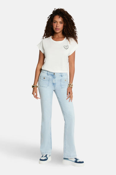 Wit T-shirt met korte mouwen van Morgan De Toi, met een hartjes applicatie, gecombineerd met een lichtblauwe jeans en witte sneakers.