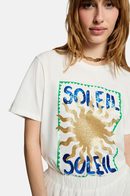 T-shirt blanc Morgan De Toi, vu de dos, porté avec une longue jupe blanche à détails en dentelle et des sandales bleues.