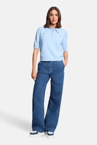 Pull bleu Morgan De Toi, à manches courtes et boutons argentés, combiné avec un jean ample et des baskets blanches.