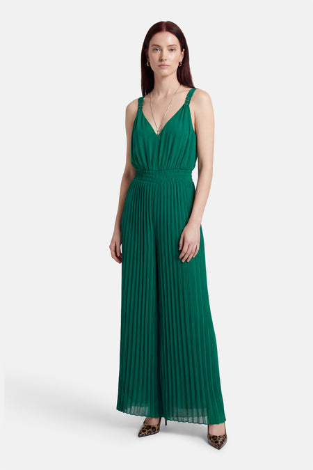Groene jumpsuit van Morgan de Toi, met plooien en gedrapeerde taille, gecombineerd met een zilveren ketting en luipaardprint pumps.
