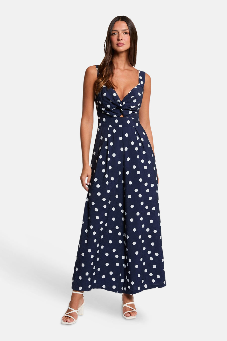 Blauwe jumpsuit van Morgan De Toi met witte stippen, een gedraaide knoopdetail en een uitsnede aan de voorkant.