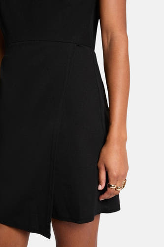 Robe sans manches noire de Morgan de Toi, avec une subtile fente et portée avec des bagues d'or.