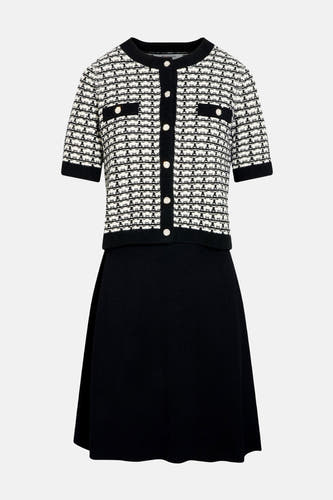 Zwarte jurk met korte mouwen van Morgan De Toi, met een wit en zwart gestreept jasje met goudkleurige knopen.