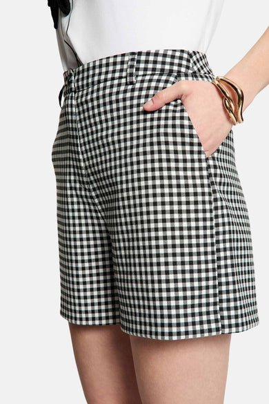 Short noir Morgan De Toi à motif à carreaux, combiné avec un t-shirt blanc et des talons.