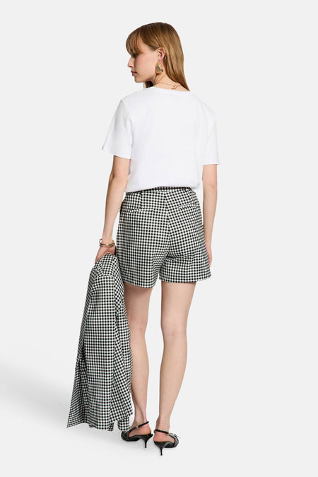 Zwarte short van Morgan De Toi met ruitpatroon, gecombineerd met een wit T-shirt en hakken.