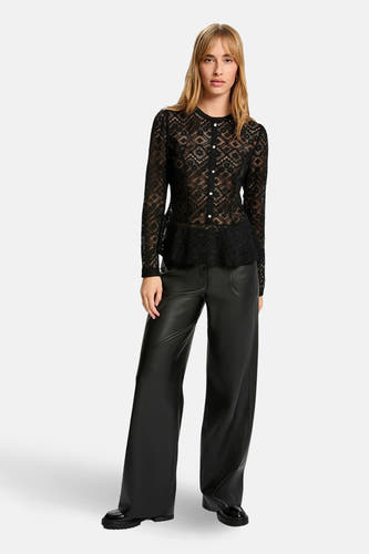 Zwarte blouse met lange mouwen van Morgan De Toi, met kanten details en een peplum silhouet, gecombineerd met zwarte leren broeken.
